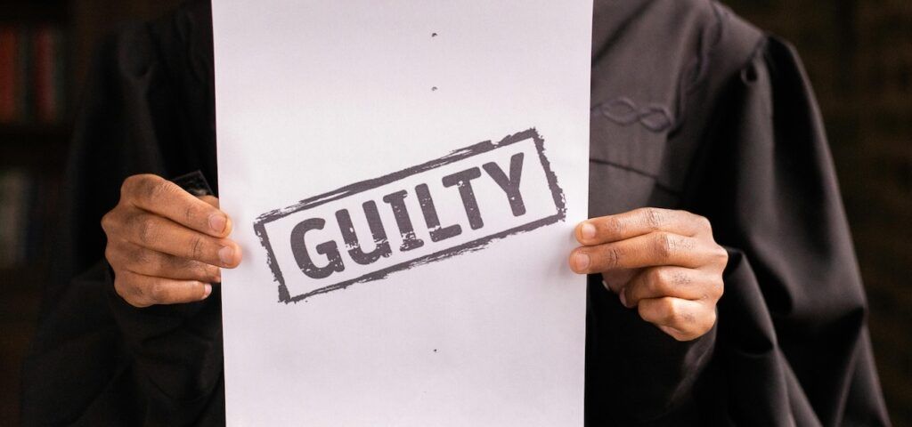 A_Judge_Holding_Paper_with_Guilty_Wording