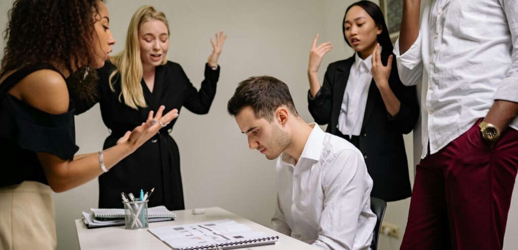 A Group of People Scolding a Man A Group of People Scolding a Man