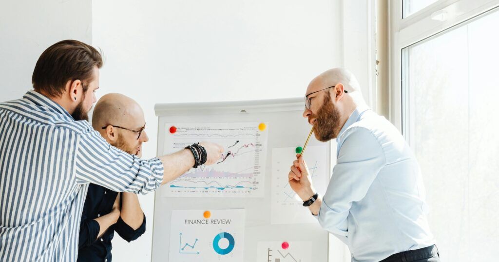 Men Discussing Stock Review Charts Men Discussing Stock Review Charts