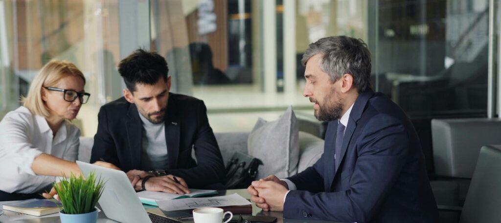 Three business people sitting around a table Three business people sitting around a table