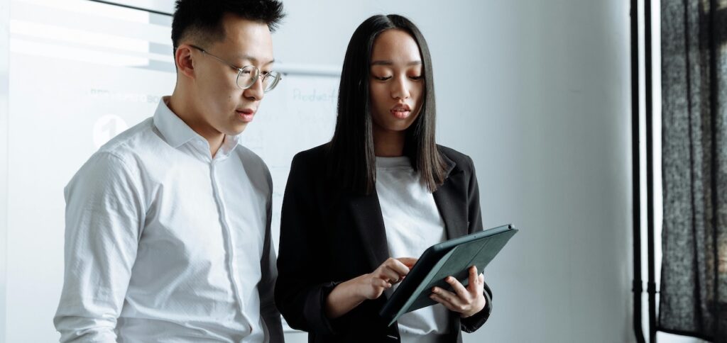 A Business Man and a Business Woman Looking at the Ipad