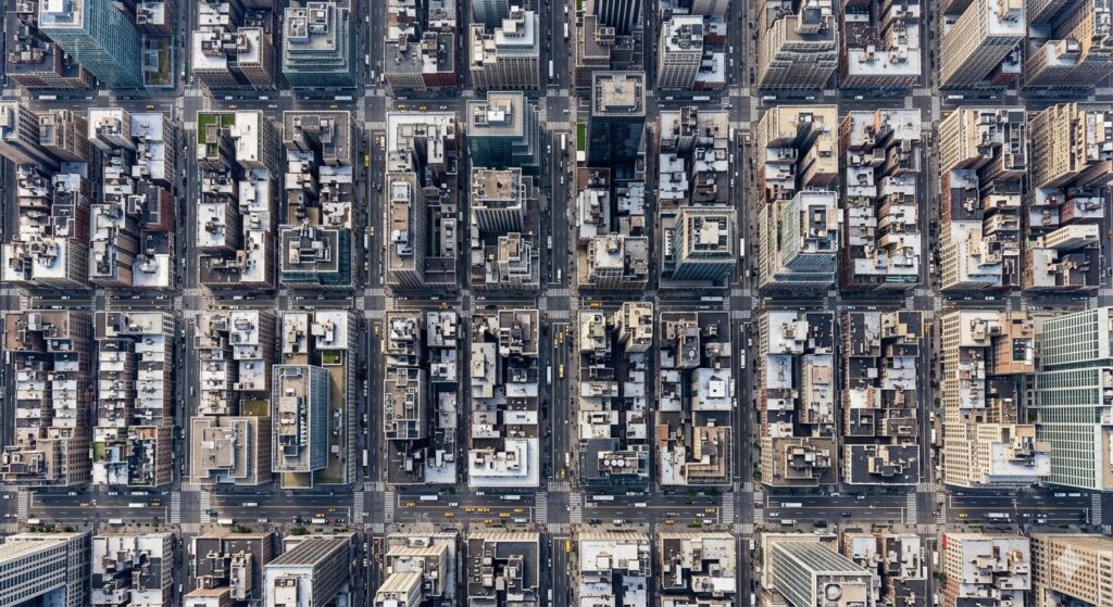 A dense city block with skyscrapers and streets, photorealistic, bird’s eye view, top-down perspective, geometric layout