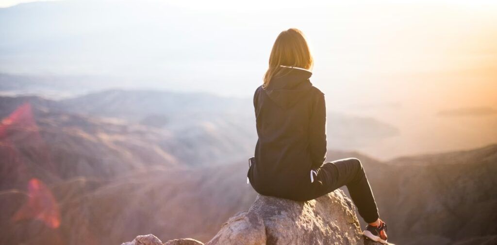 a_woman_sitting_on_a_cliff