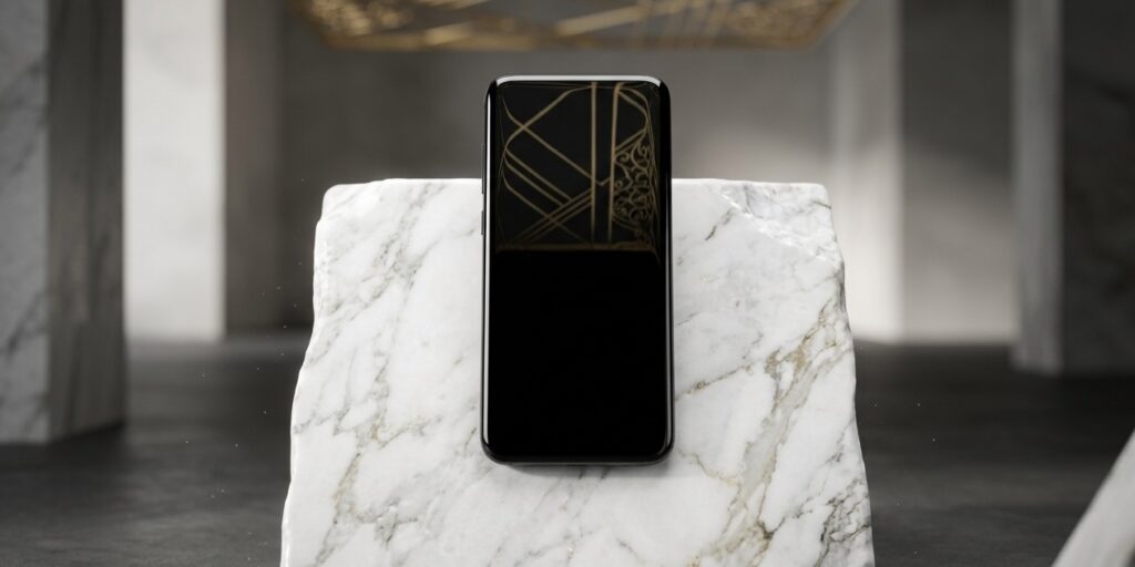 Studio shot of a black, sleek, minimalist high-end ceramic smartphone resting on a block of pure white marble