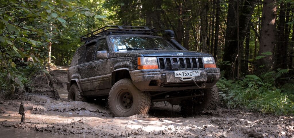 Jeep navigates through muddy terrain in a dense Russian forest Jeep navigates through muddy terrain in a dense Russian forest