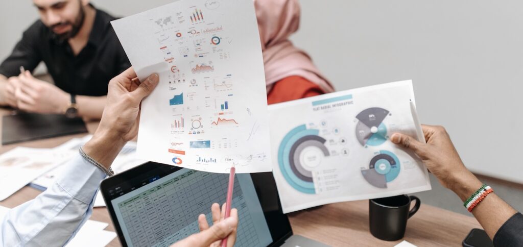 Team analyzing graphs and data during a business meeting Team analyzing graphs and data during a business meeting