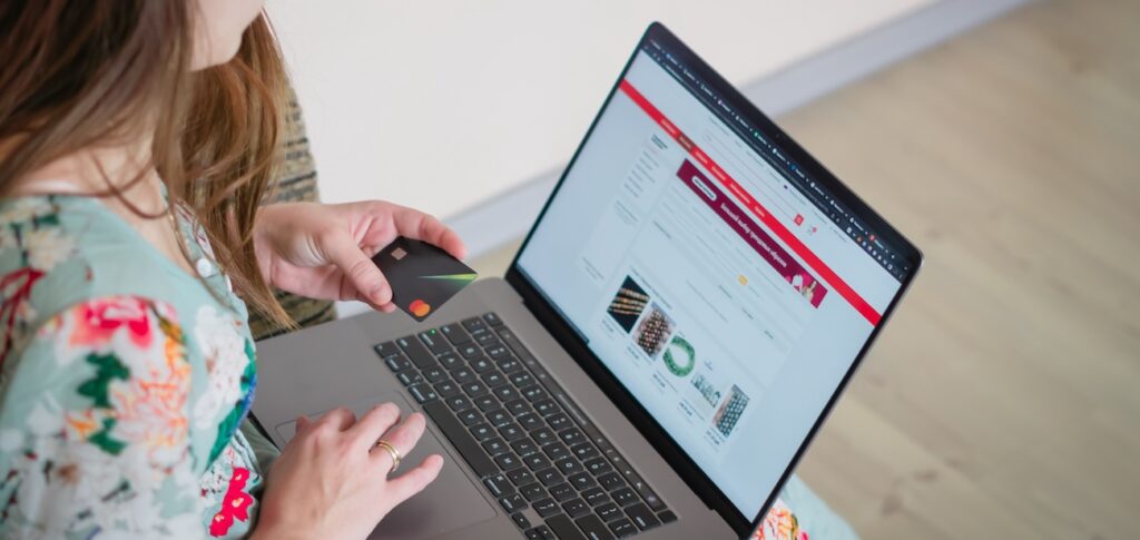 Woman in floral dress shopping online with a laptop Woman in floral dress shopping online with a laptop
