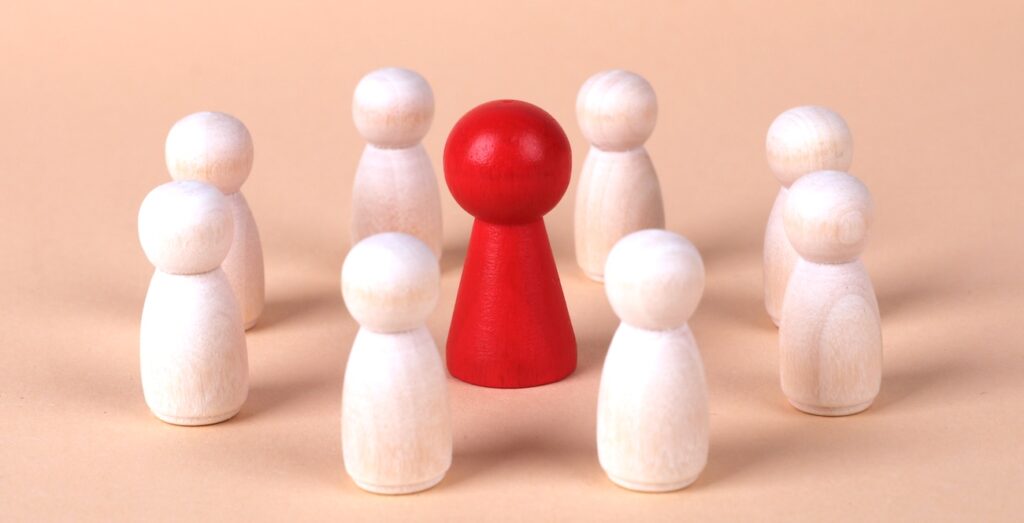 Wooden figures illustrating leadership with a central red figure