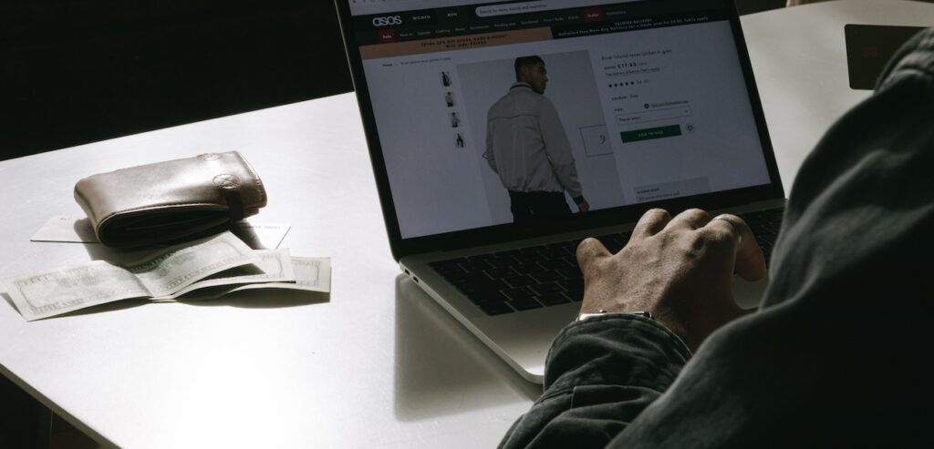 a man shopping for clothes online at home using a laptop a man shopping for clothes online at home using a laptop