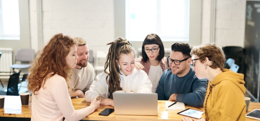 team of professionals collaborates happily around a laptop team of professionals collaborates happily around a laptop