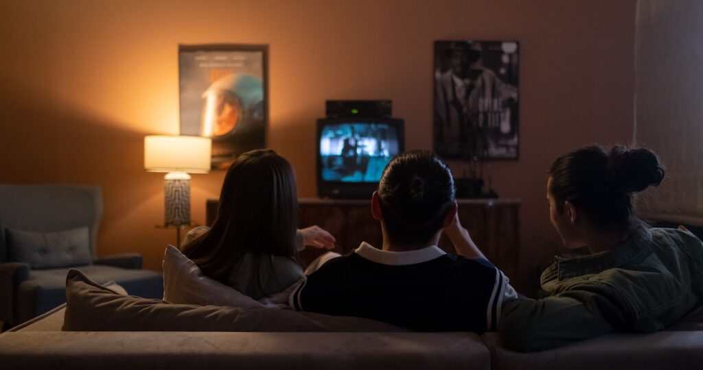 Three people are watching news at home Three people are watching news at home