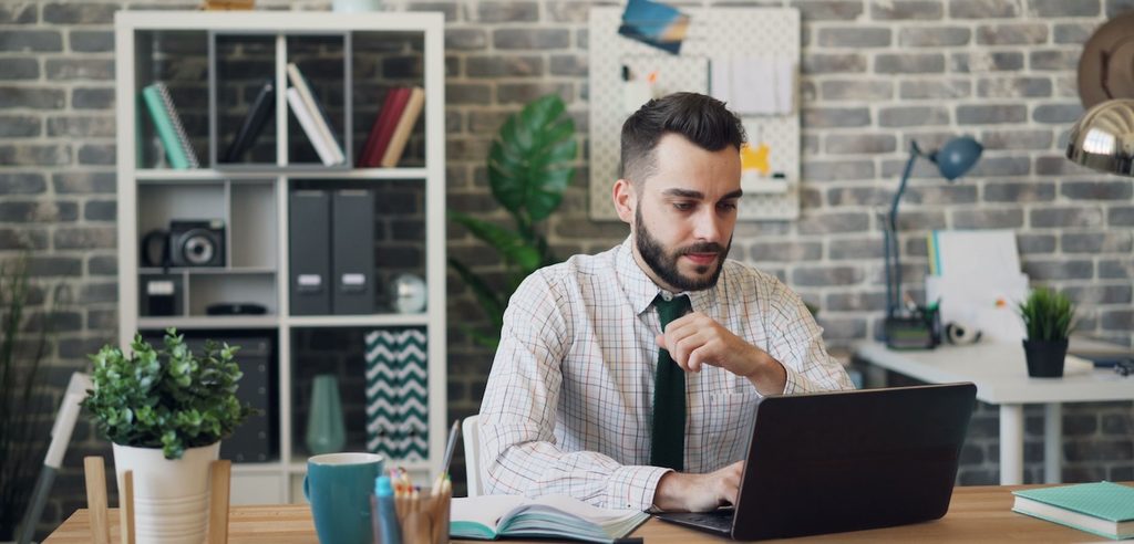 a man working on laptop in a stylish office setting a man working on laptop in a stylish office setting