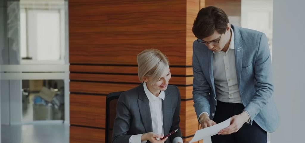 Two business colleagues discussing reports in modern office Two business colleagues discussing reports in modern office