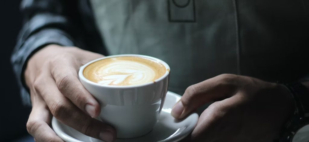 a man holding a glass of coffee a man holding a glass of coffee