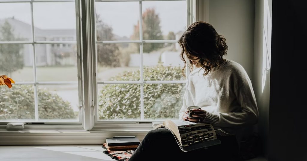 a woman reading book in living room